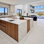 Rancho Santa Fe Lago Vista kitchen by Aranelli Design — walnut and white-gloss cabinetry with a quartzite waterfall island, open to the great room and mountain-view terrace