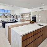 Rancho Santa Fe Lago Vista kitchen by Aranelli Design — marble waterfall island with butcher-block inlay beside the dining area and floor-to-ceiling views