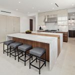 Rancho Santa Fe Lago Vista kitchen by Aranelli Design — bright open kitchen with a quartzite waterfall island, bar seating, and integrated white-gloss appliance wall